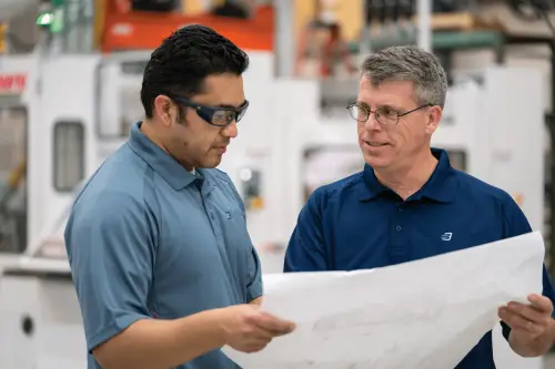 Two employees looking at paper